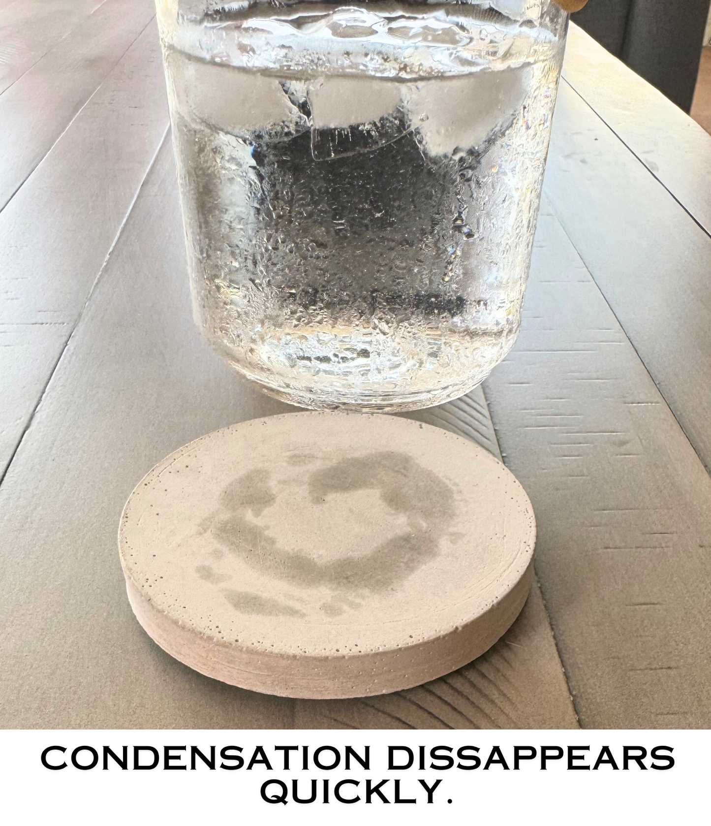 Round cement gray concrete coaster quickly absorbing condensation left by a glass being lifted, showing the moisture fading.