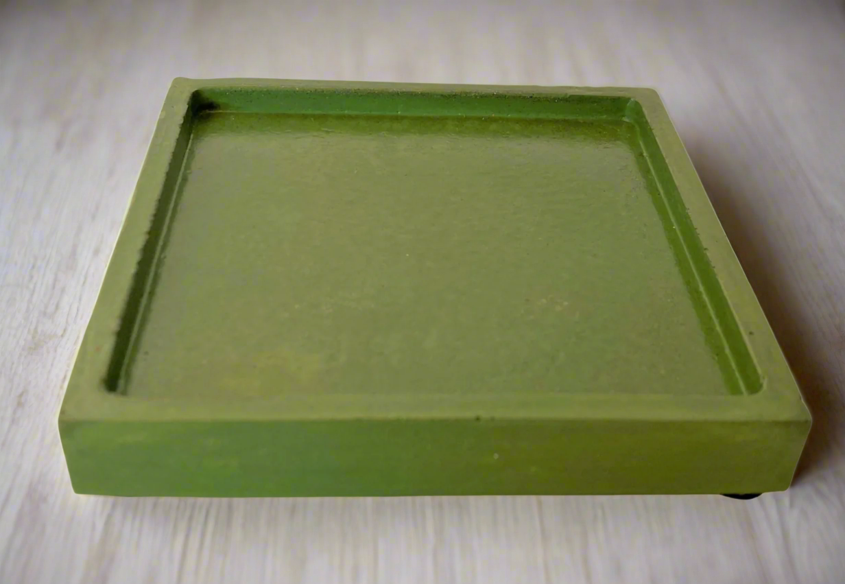 A single glossy Green square concrete coaster tray with a subtle lip is shown from a low angle against a white background.
